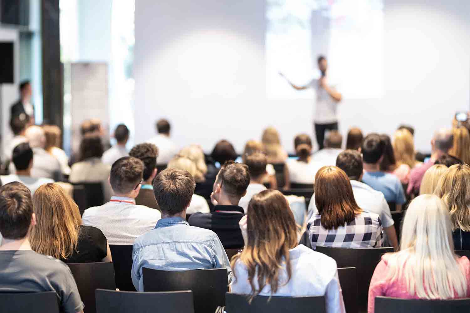 Business speaker giving a talk at business conference event.